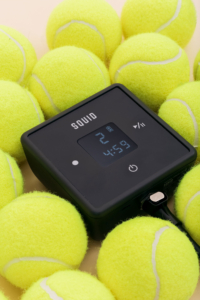 A group of yellow tennis balls surrounded by a device.