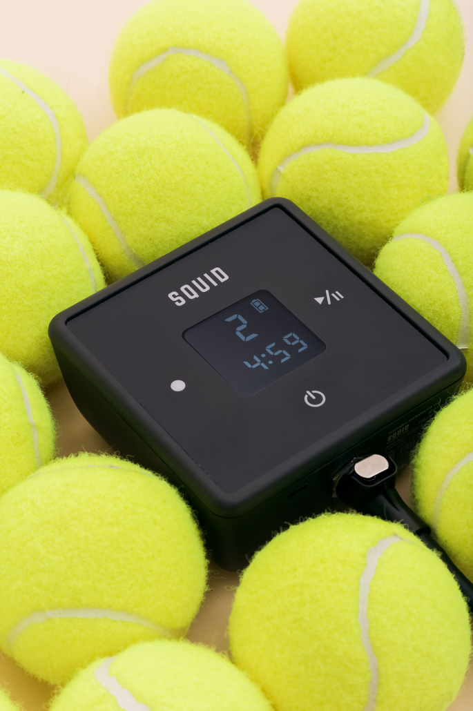 A group of yellow tennis balls surrounded by a device.