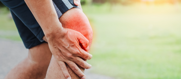 A person holding a knee in pain from arthritis