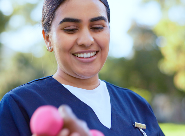 A smiling clinician in scrubs