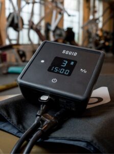 The Squid Go cold compression pump on a gym floor