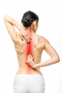 A woman shown from behind with the back and neck highlighted to show pain