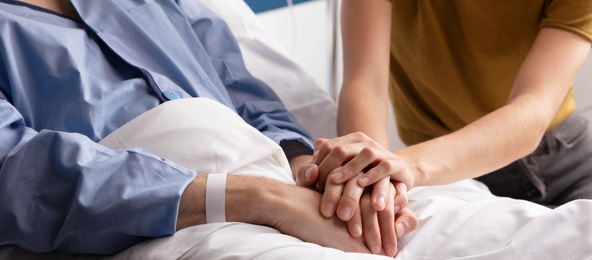 Two people holding hands in comfort during recovery